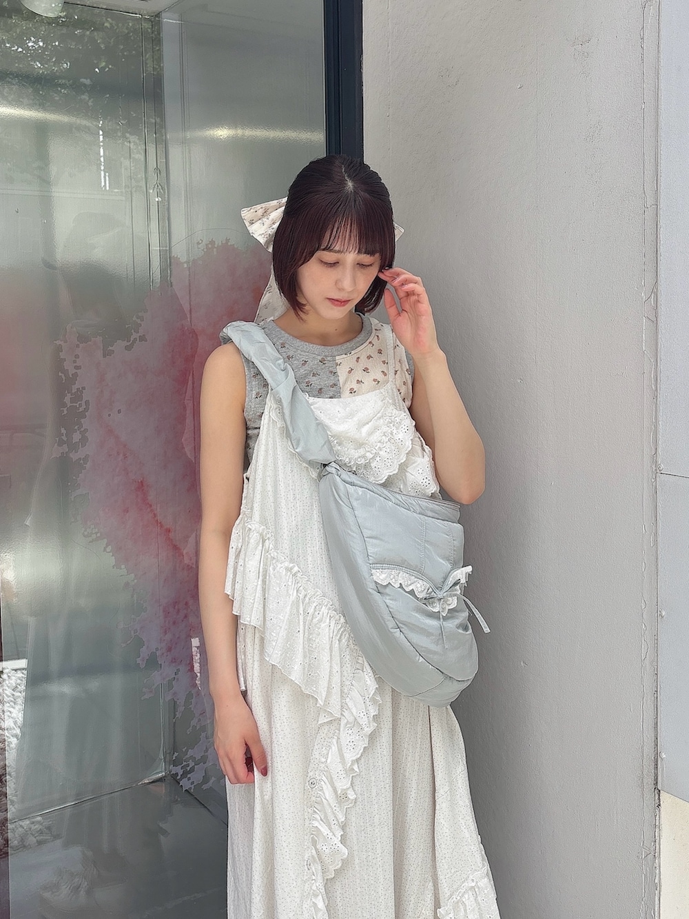 ブルー系のショルダーバッグ、ホワイト系のワンピース、ホワイト系のサンダルを着用したレディースの夏コーディネートの3枚目の写真