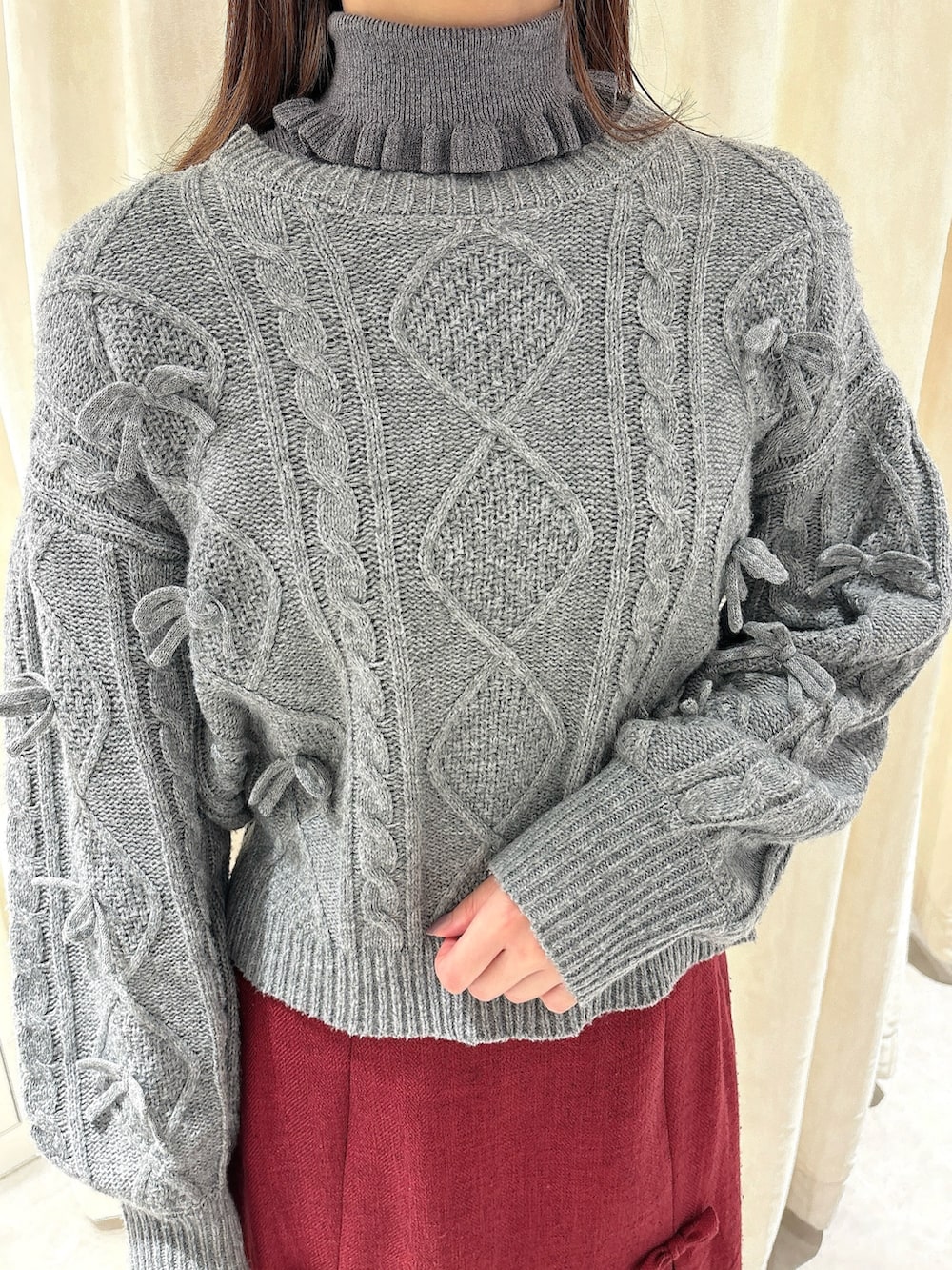 グレー系のニット/セーター、レッド系のスカート、ホワイト系のローファーを着用したレディースの秋コーディネートの5枚目の写真