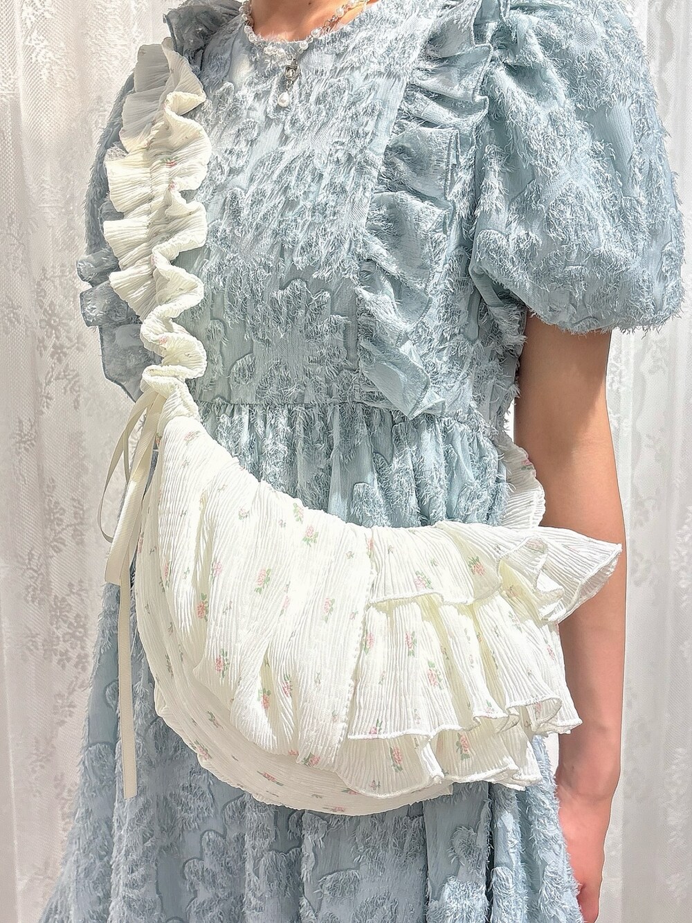 ブルー系のワンピース、ホワイト系のショルダーバッグ、ピンク系のブーツを着用したレディースの春コーディネートの6枚目の写真