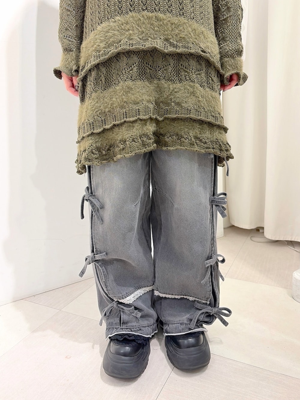 グレー系のデニムパンツ、ホワイト系のスニーカー、グリーン系のワンピースを着用したレディースの夏コーディネートの7枚目の写真