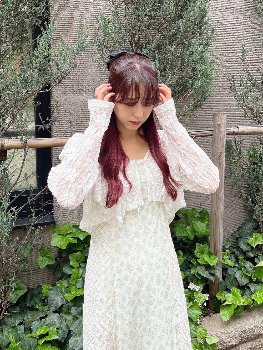 ピンク系のパンプス、グリーン系のワンピース、ホワイト系のカーディガン/ボレロを着用したレディースの春コーディネートの2枚目の写真