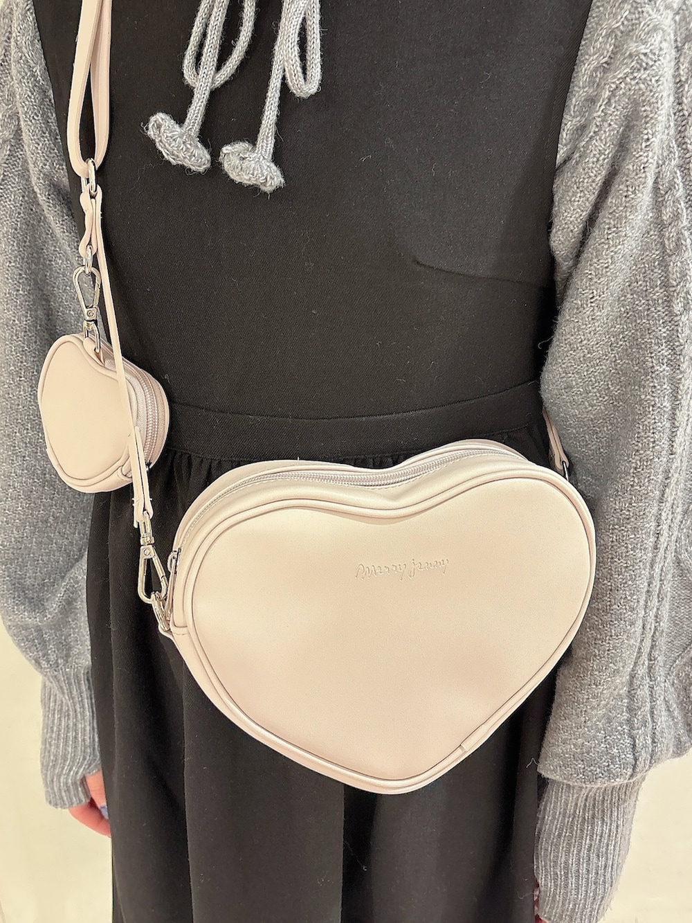 グレー系のニット/セーター、ブラック系のワンピース、ブラック系のブーツを着用したレディースの冬コーディネートの5枚目の写真