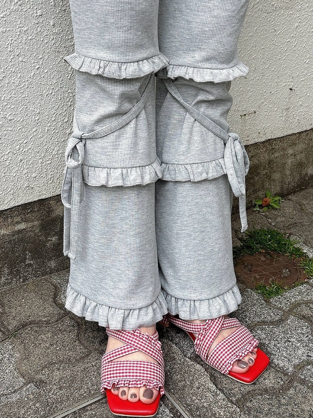 ホワイト系のTシャツ/カットソー、グレー系のスウェットパンツ、レッド系のサンダルを着用したレディースの春コーディネートの4枚目の写真