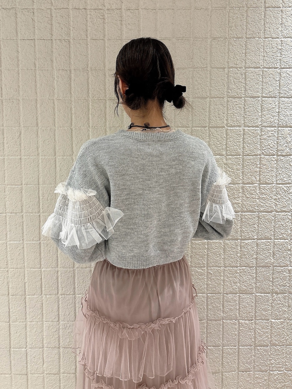 ホワイト系のTシャツ/カットソー、グレー系のカーディガン/ボレロ、ピンク系のスカートを着用したレディースの秋コーディネートの4枚目の写真