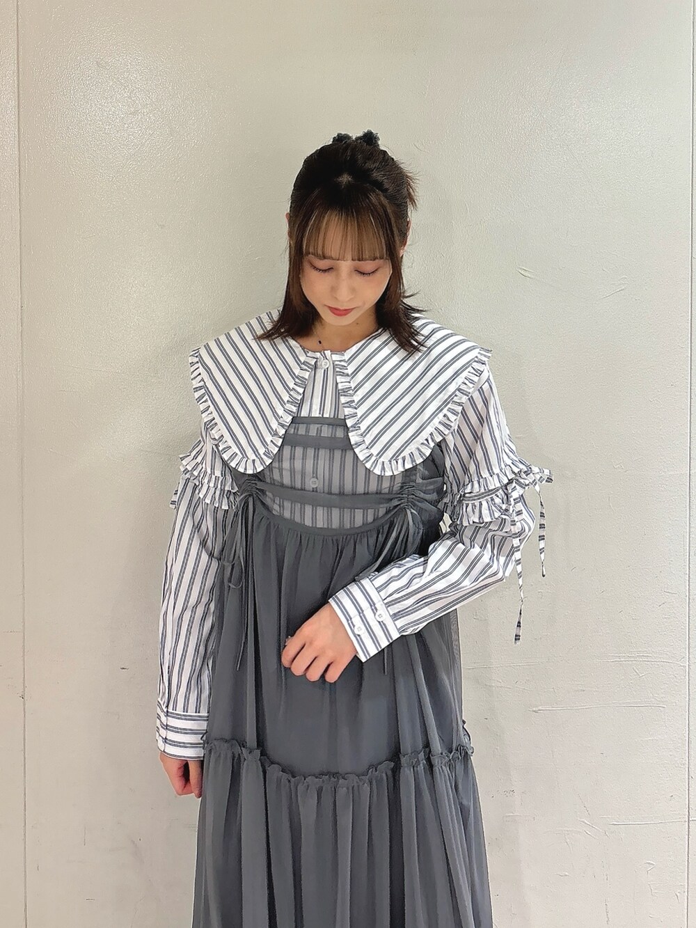 グレー系のワンピース、ホワイト系のシャツ/ブラウス、ブラック系のスニーカーを着用したレディースの夏コーディネートの3枚目の写真