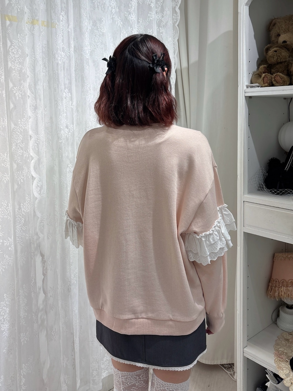 ピンク系のスウェット、グレー系のスカート、ホワイト系のスニーカーを着用したレディースの秋コーディネートの4枚目の写真