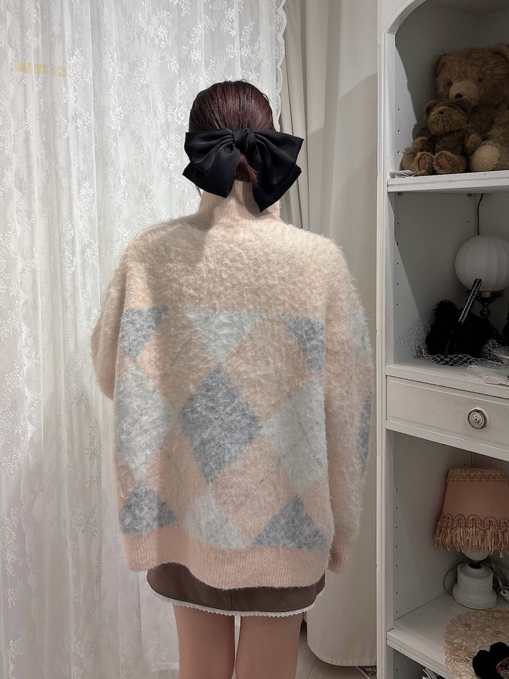 ピンク系のニット/セーター、ブラウン系のスカート、ピンク系のブーツを着用したレディースの秋コーディネートの4枚目の写真