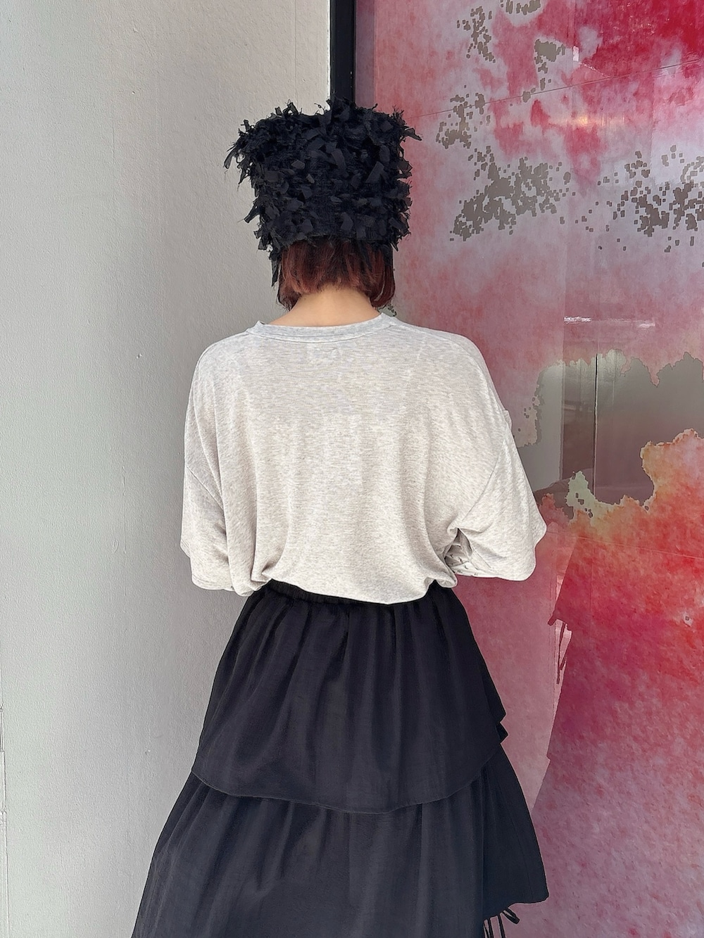 グレー系のTシャツ/カットソー、ブラック系のスカート、ブラック系のパンプスを着用したレディースの夏コーディネートの4枚目の写真