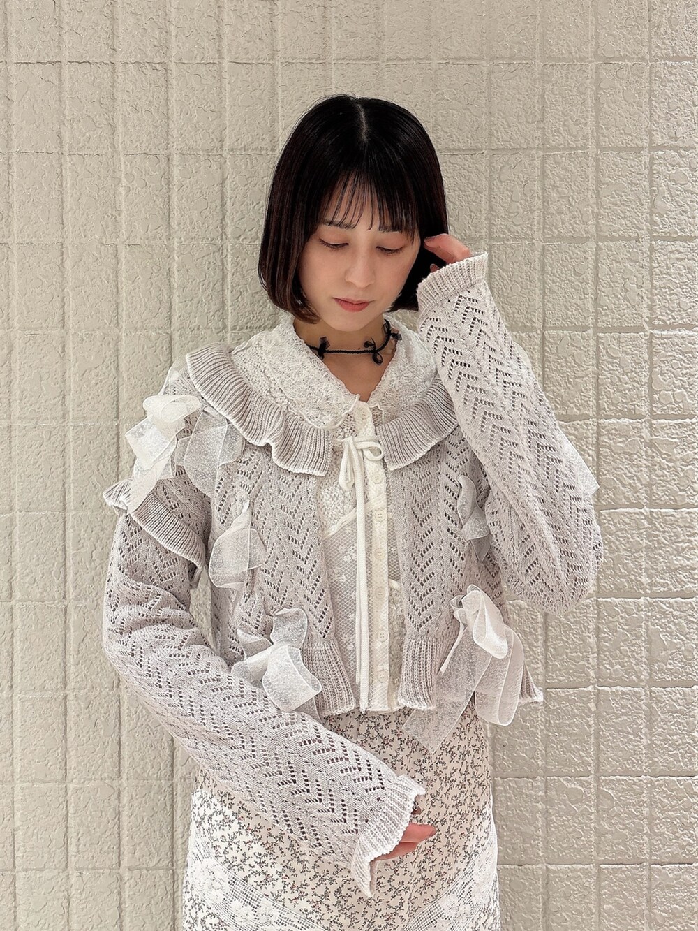 ホワイト系のカーディガン/ボレロ、グレー系のカーディガン/ボレロ、ホワイト系のスカートを着用したレディースの冬コーディネートの3枚目の写真