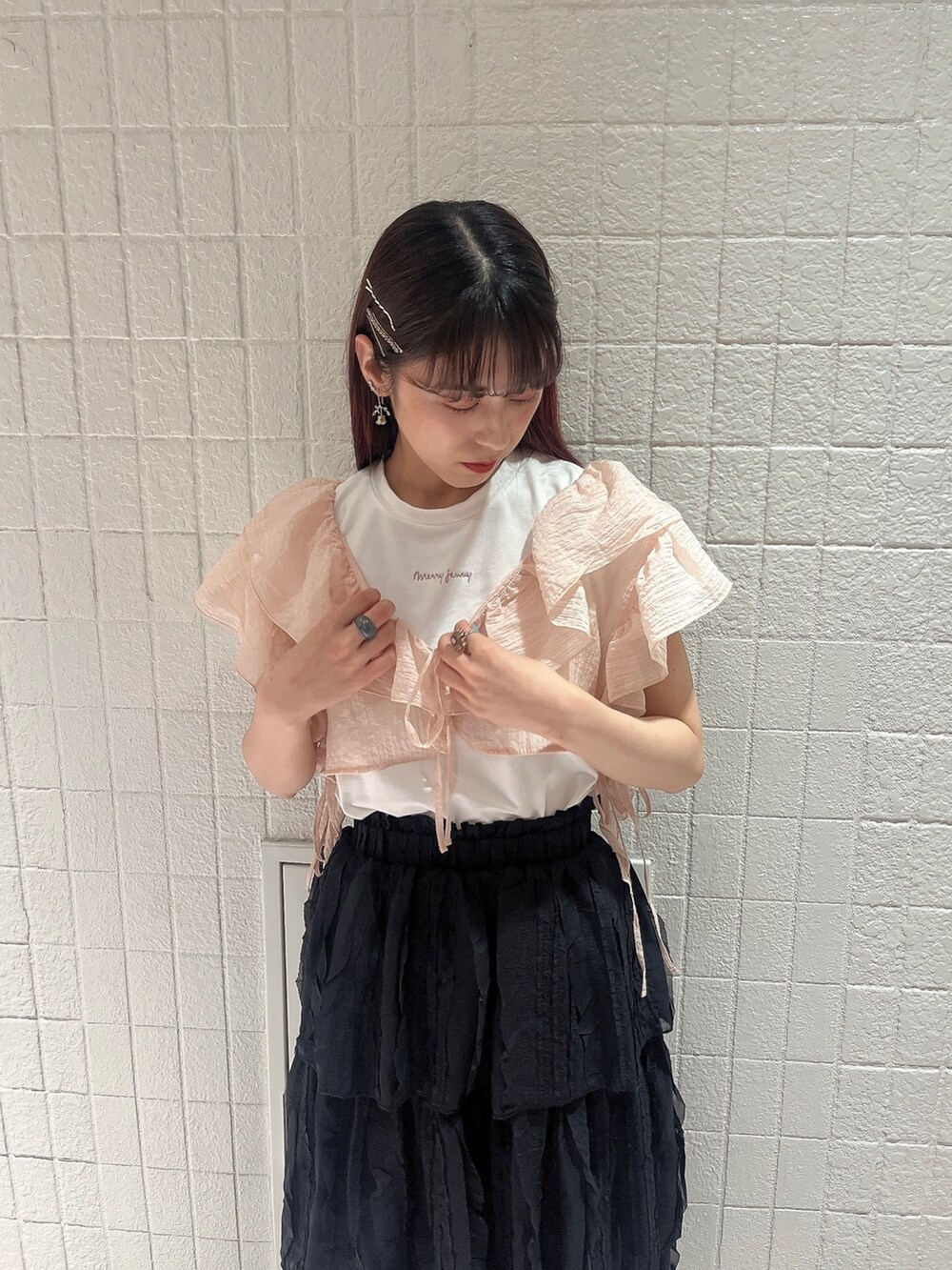 ブラック系のスカート、ゴールド系のパンプス、ホワイト系のTシャツ/カットソーを着用したレディースの夏コーディネートの2枚目の写真