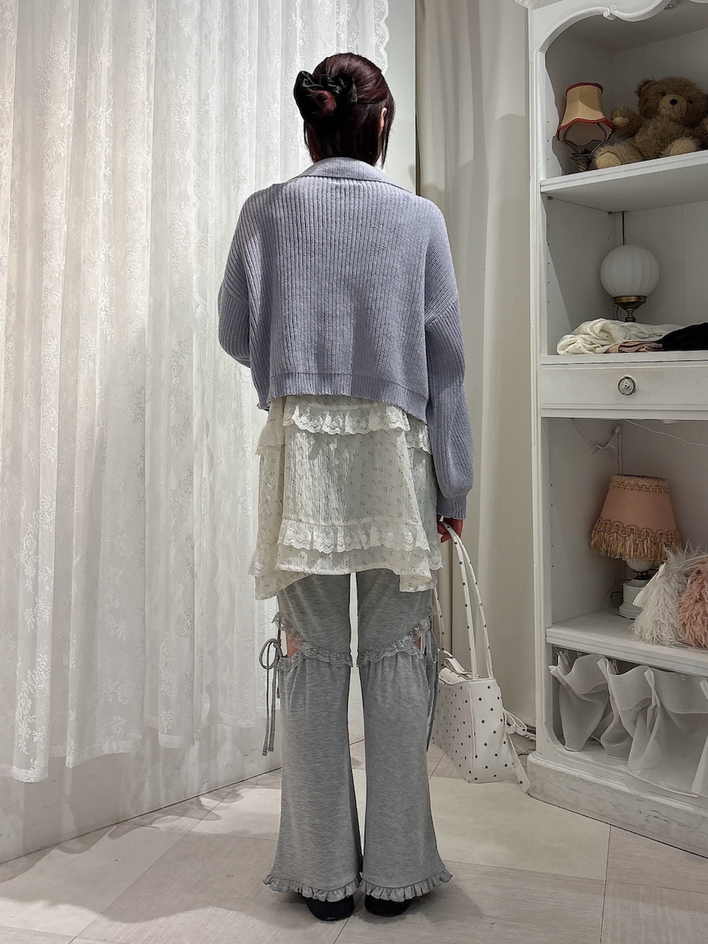 ブルー系のカーディガン/ボレロ、ホワイト系のチュニック、その他のハンドバッグを着用したレディースの夏コーディネートの2枚目の写真