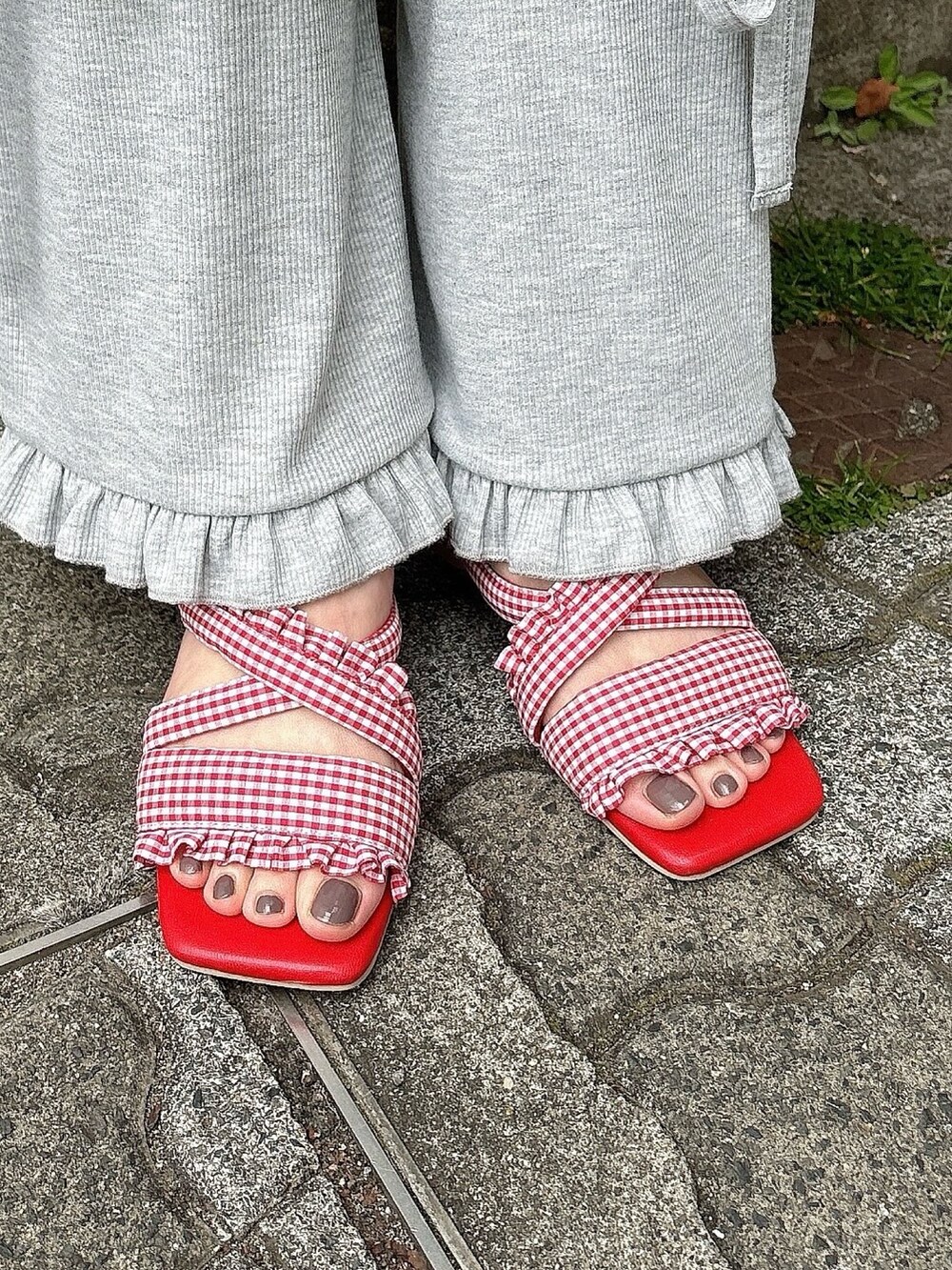 ホワイト系のTシャツ/カットソー、グレー系のスウェットパンツ、レッド系のサンダルを着用したレディースの春コーディネートの5枚目の写真