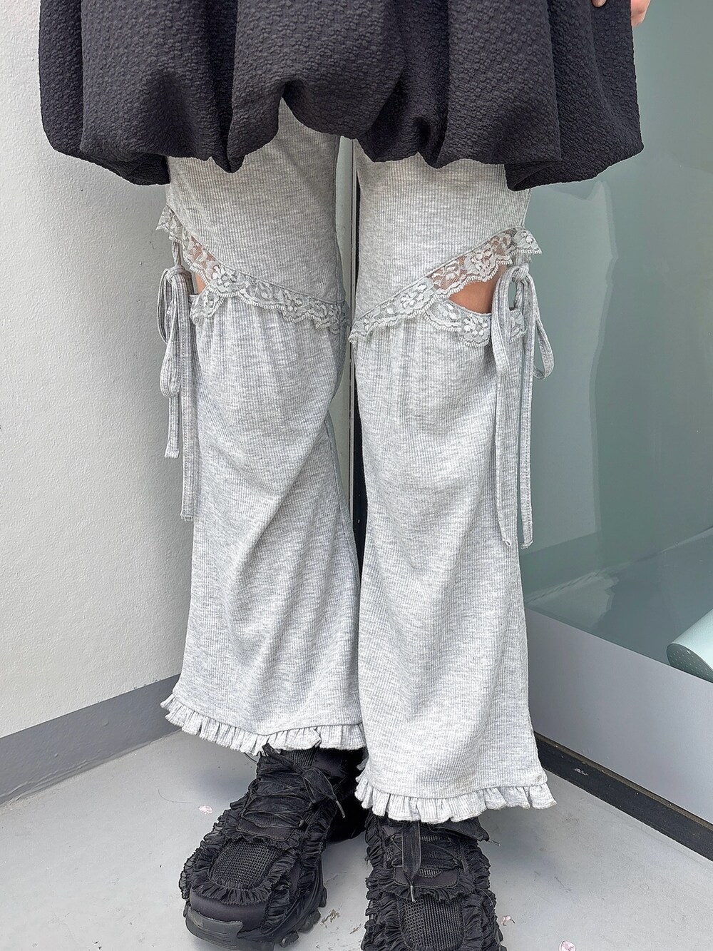 グレー系のスウェットパンツ、ブラック系のスニーカー、ブラック系のワンピースを着用したレディースの春コーディネートの7枚目の写真