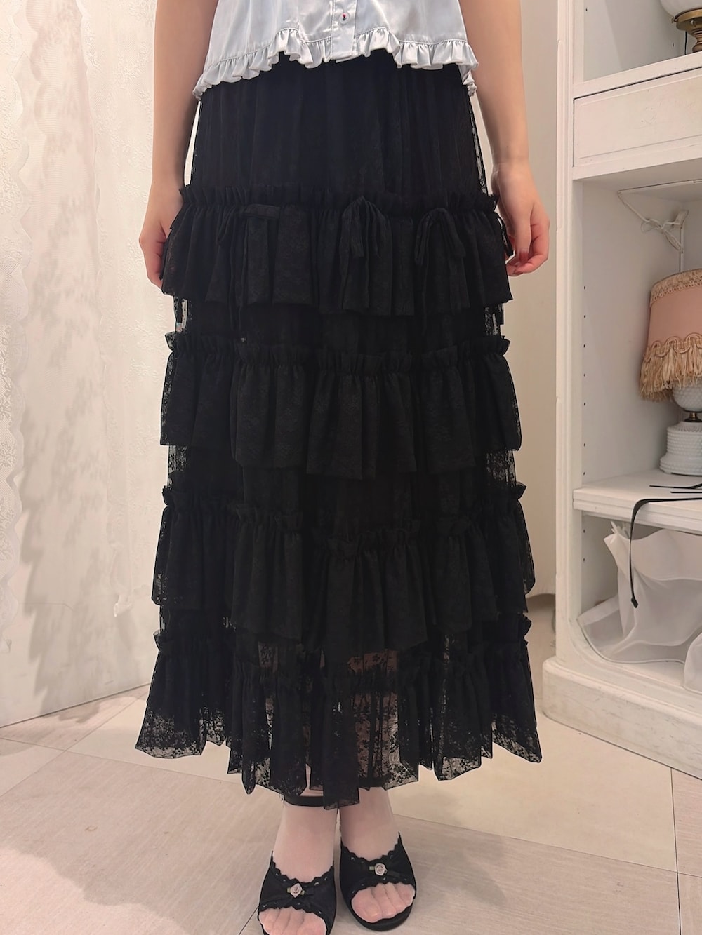 ブルー系のシャツ/ブラウス、ブラック系のスカート、ブラック系のサンダルを着用したレディースの春コーディネートの6枚目の写真