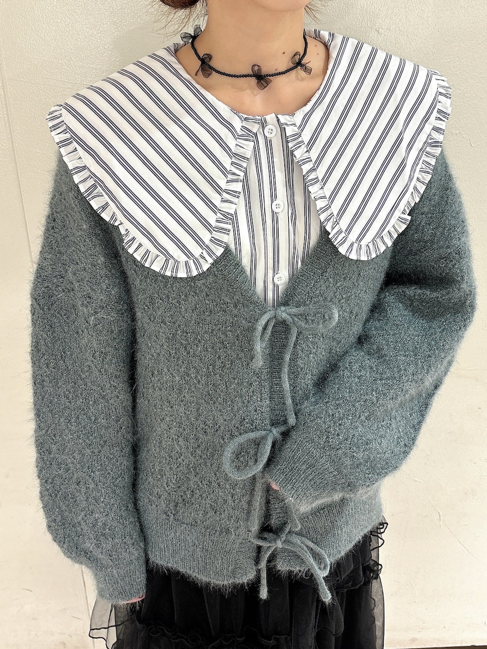 ホワイト系のシャツ/ブラウス、グリーン系のカーディガン/ボレロ、ブラック系のスカートを着用したレディースの夏コーディネートの5枚目の写真