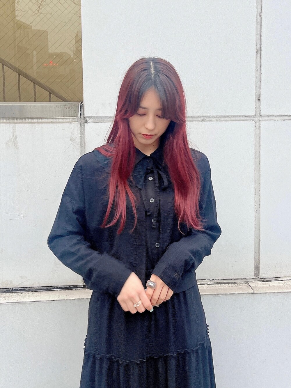 ピンク系のパンプス、ブラック系のスカート、ブラック系のチュニックを着用したレディースの春コーディネートの2枚目の写真