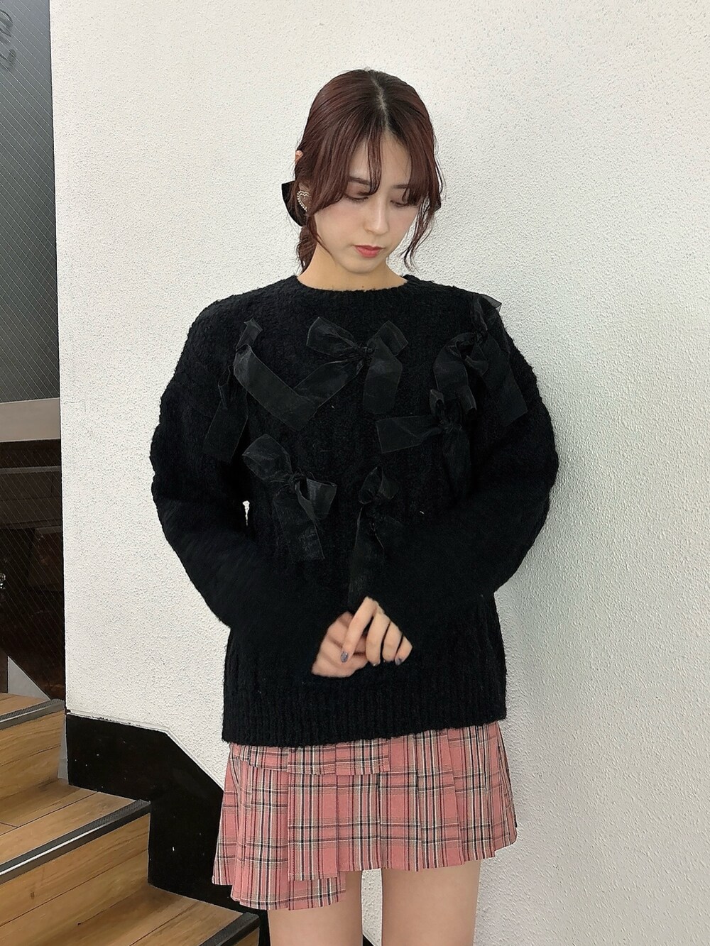 ピンク系のスカート、ブラウン系のブーツ、ブラック系のダウンジャケット/コートを着用したレディースの冬コーディネートの5枚目の写真