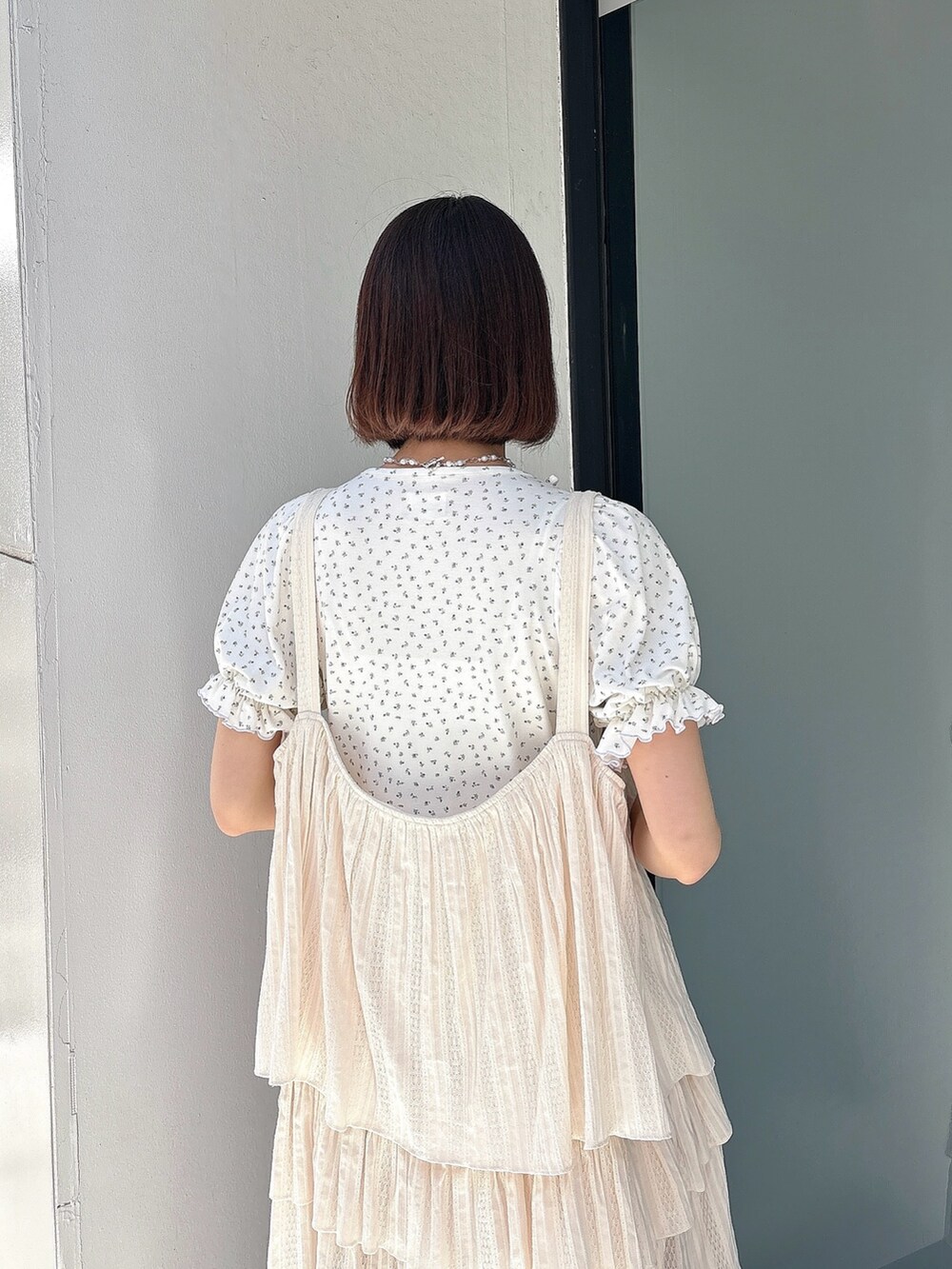 ホワイト系のワンピース、ブルー系のTシャツ/カットソー、ホワイト系のサンダルを着用したレディースの春コーディネートの4枚目の写真