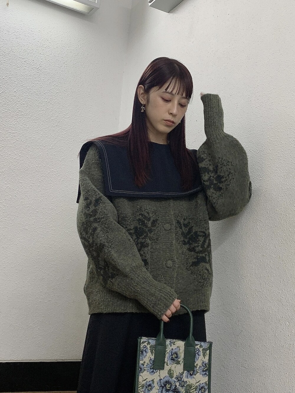 ブラック系のワンピース、グレー系のカーディガン/ボレロ、ベージュ系のハンドバッグを着用したレディースの秋コーディネートの2枚目の写真