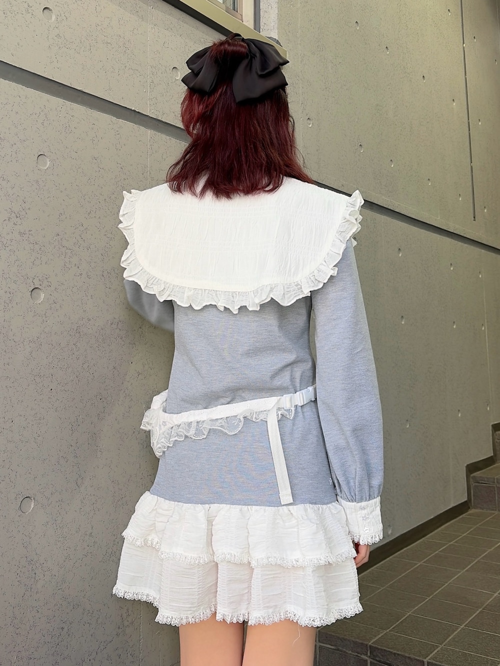 グレー系のワンピース、ブラック系のスニーカー、ホワイト系のボディバッグ/ウエストポーチを着用したレディースの冬コーディネートの4枚目の写真