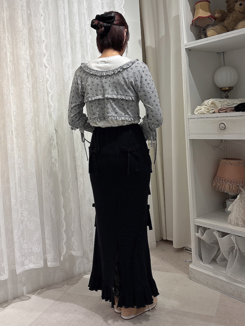 ブラック系のスカート、グレー系のカーディガン/ボレロ、ホワイト系のTシャツ/カットソーを着用したレディースの夏コーディネートの2枚目の写真