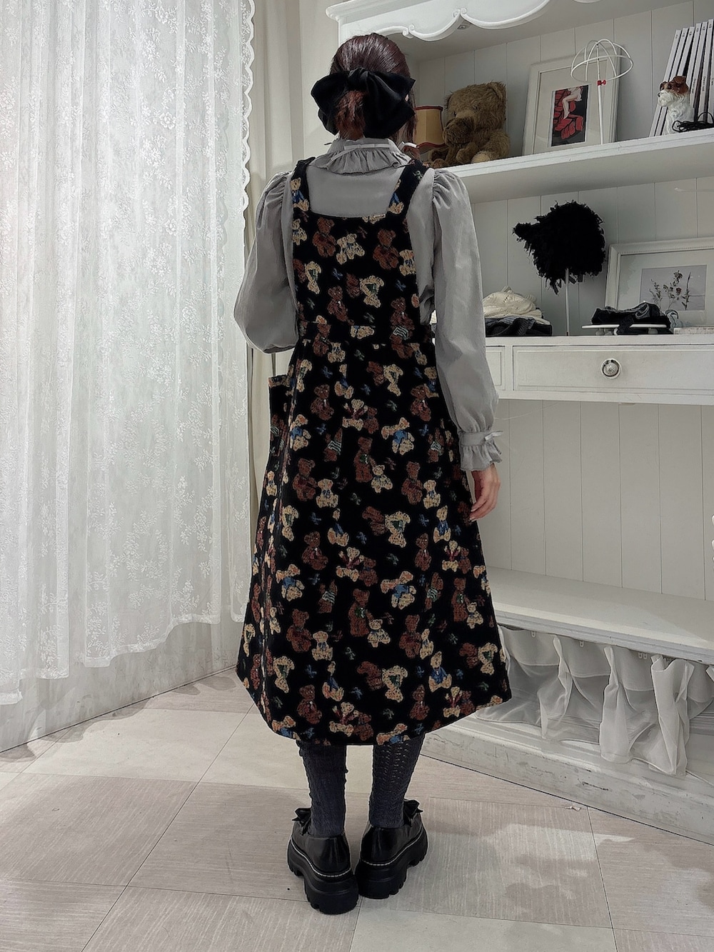 グレー系のシャツ/ブラウス、ブラック系のジャンパースカート、ブラック系のローファーを着用したレディースの秋コーディネートの2枚目の写真