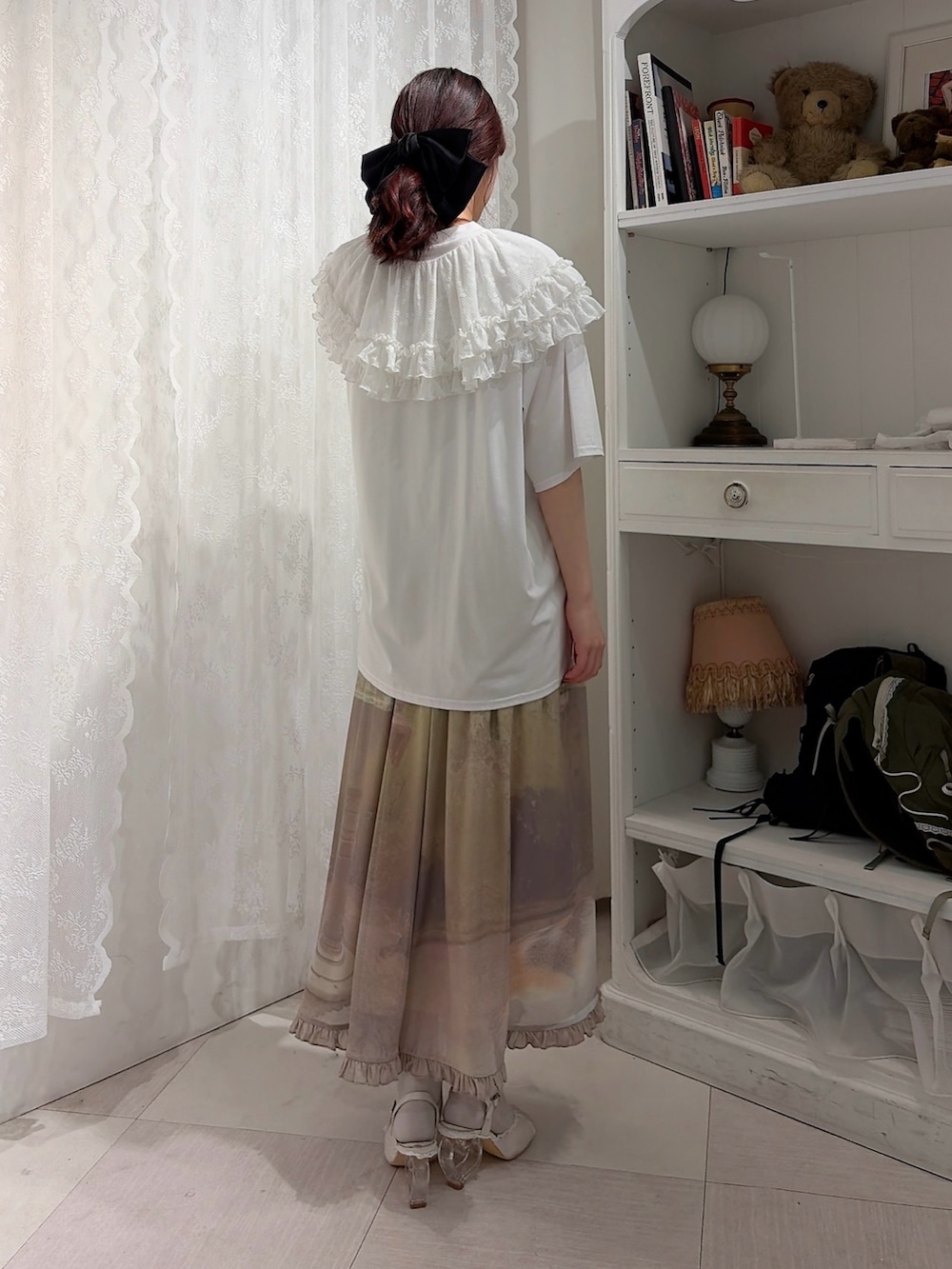 ホワイト系のTシャツ/カットソー、グリーン系のスカート、ホワイト系のサンダルを着用したレディースの春コーディネートの2枚目の写真