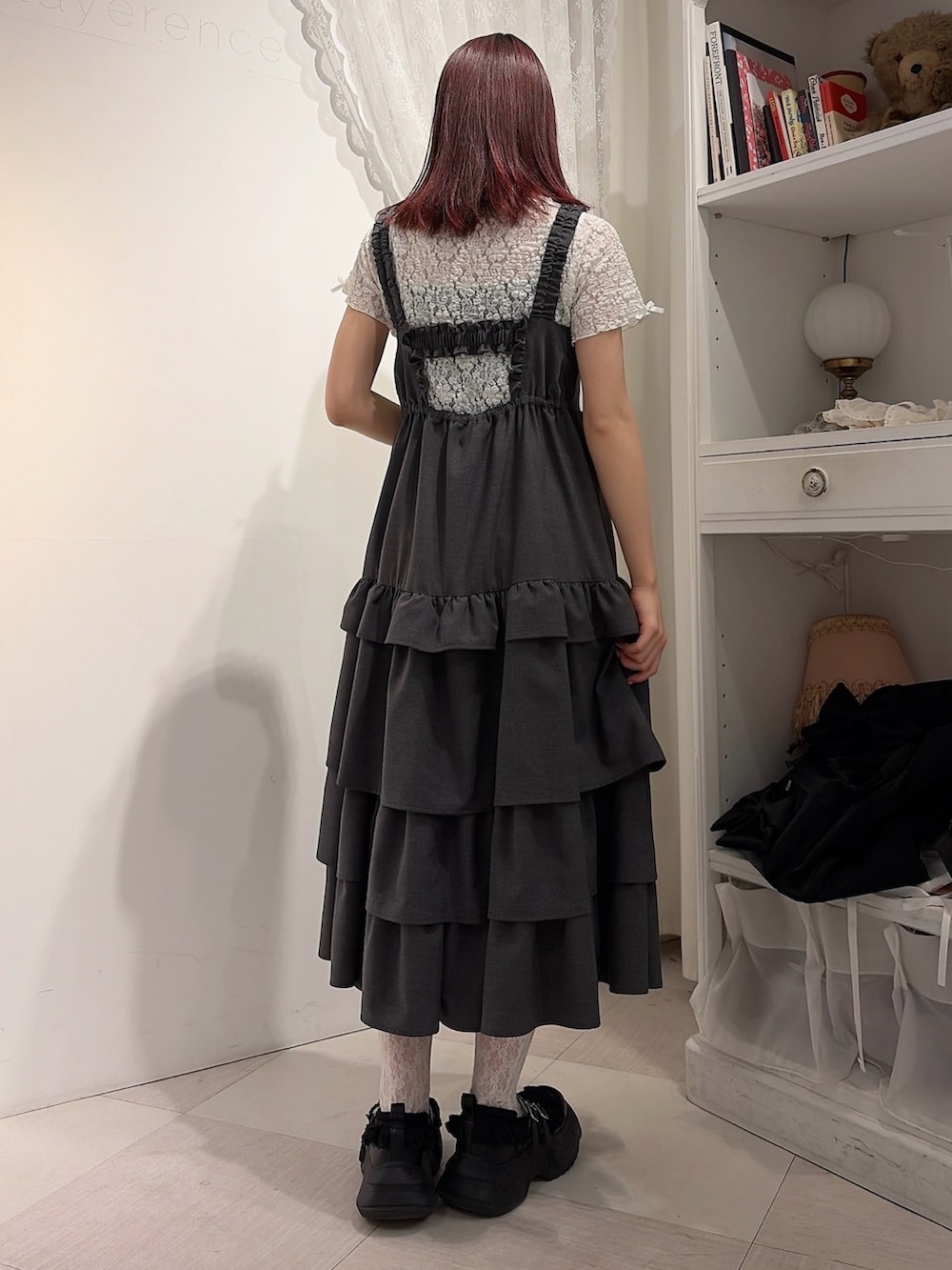 グレー系のワンピース、ホワイト系のTシャツ/カットソー、ブラック系のスニーカーを着用したレディースの春コーディネートの2枚目の写真