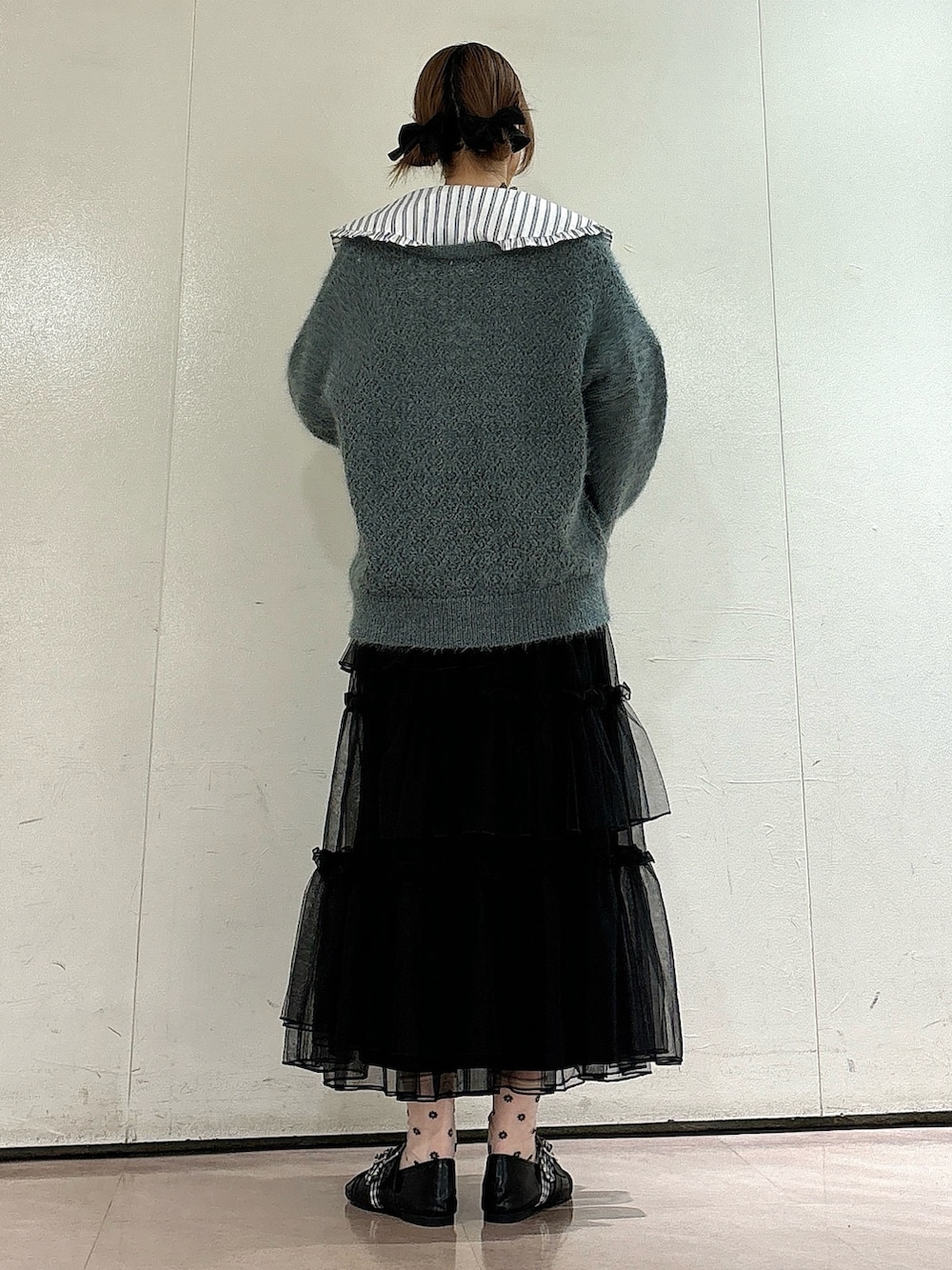 ホワイト系のシャツ/ブラウス、グリーン系のカーディガン/ボレロ、ブラック系のスカートを着用したレディースの夏コーディネートの2枚目の写真