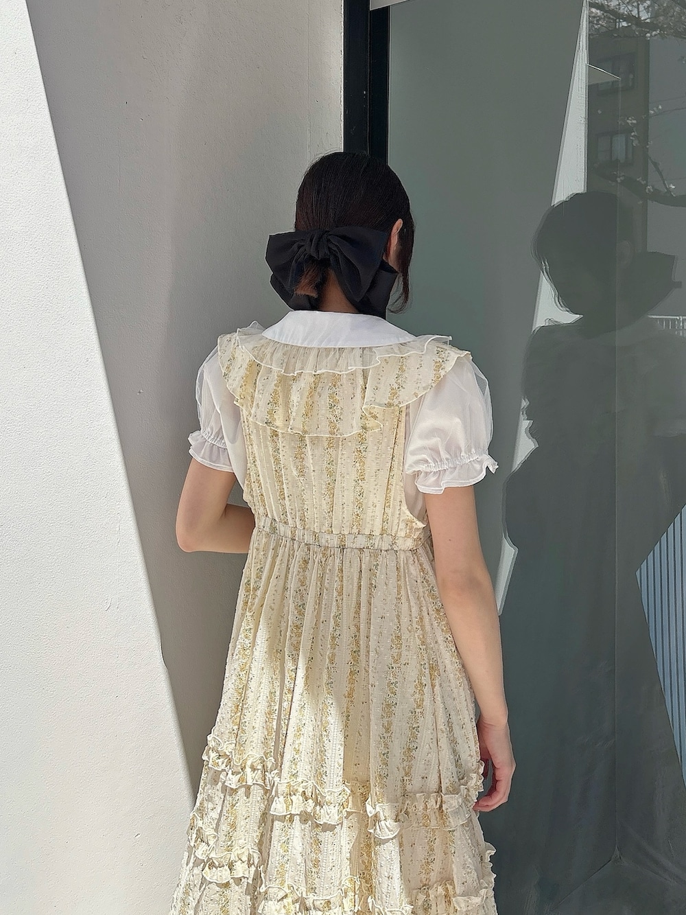 ホワイト系のシャツ/ブラウス、イエロー系のワンピース、ホワイト系のサンダルを着用したレディースの春コーディネートの4枚目の写真