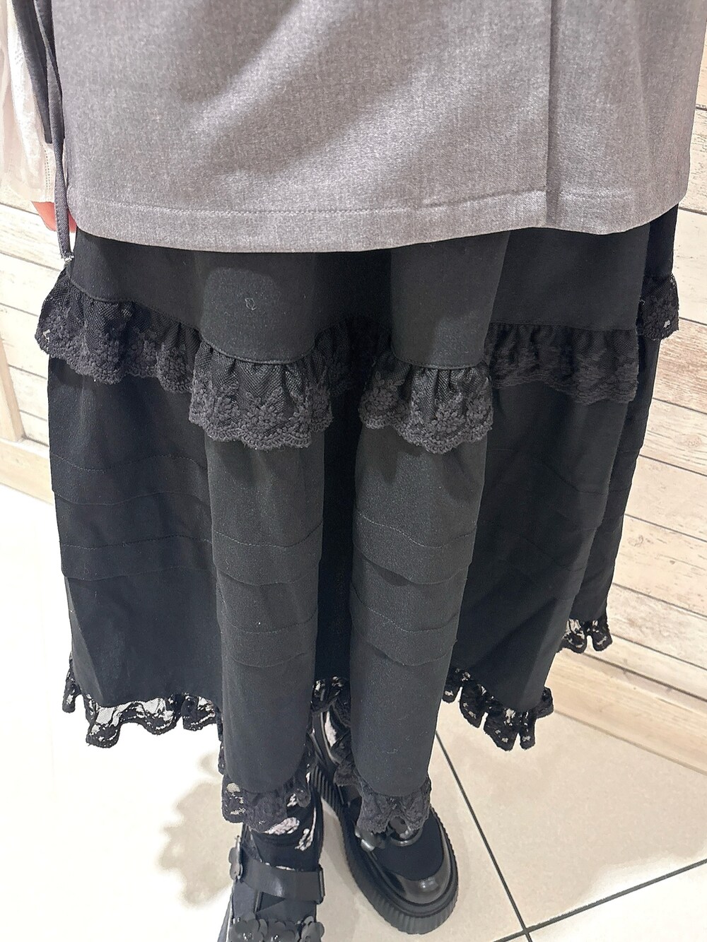 ブラック系のシャツ/ブラウス、グレー系のテーラードジャケット、ブラック系のスカートを着用したレディースの冬コーディネートの6枚目の写真