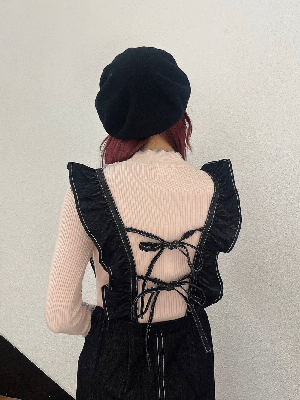 ブラック系のワンピース、ブラック系のスニーカー、ピンク系のニット/セーターを着用したレディースの秋コーディネートの3枚目の写真