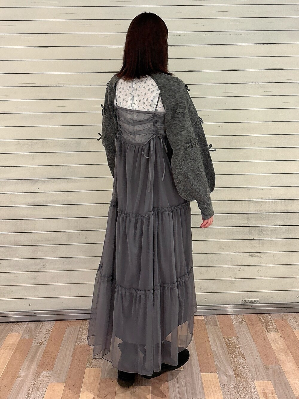 グレー系のワンピース、ブラック系のバレエシューズ、グレー系のカーディガン/ボレロを着用したレディースの秋コーディネートの2枚目の写真