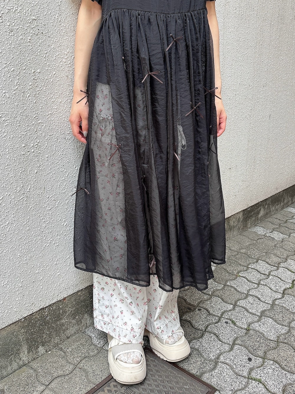 ブラック系のシャツ/ブラウス、ブラック系のワンピース、ホワイト系のスラックスを着用したレディースの春コーディネートの6枚目の写真