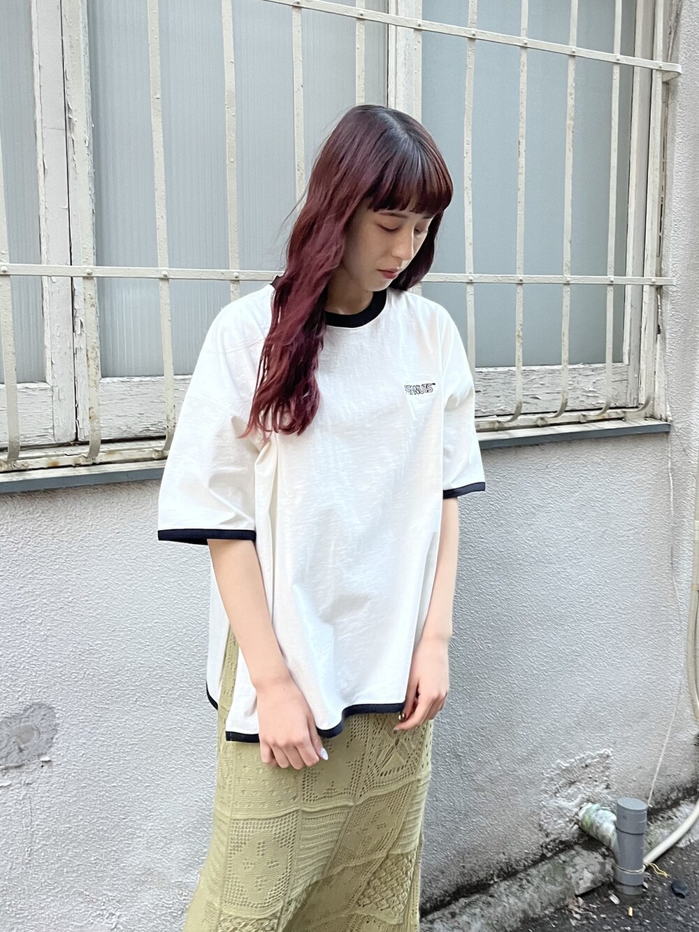 グリーン系のスカート、ブラック系のサンダル、ブラック系のトートバッグを着用したレディースの冬コーディネートの3枚目の写真