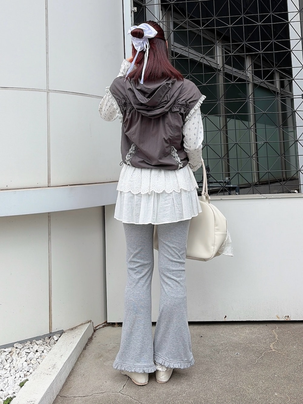 ブルー系のTシャツ/カットソー、グレー系のベスト、ホワイト系のボストンバッグを着用したレディースの春コーディネートの2枚目の写真