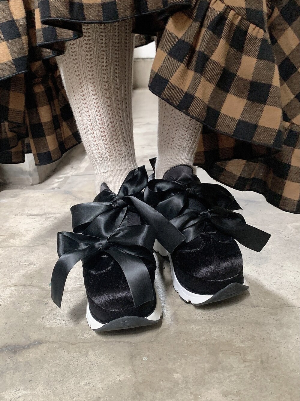 ブラック系のスニーカー、オレンジ系のスカート、ブラック系のスウェットを着用したレディースの秋コーディネートの3枚目の写真