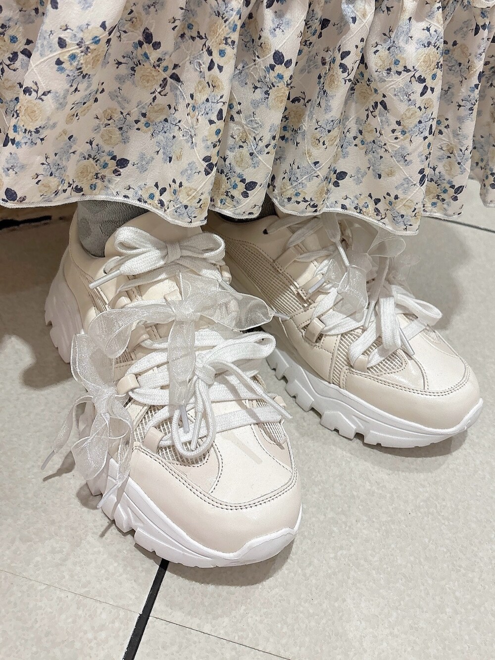 イエロー系のスカート、ホワイト系のスニーカー、ホワイト系のシャツ/ブラウスを着用したレディースの春コーディネートの7枚目の写真