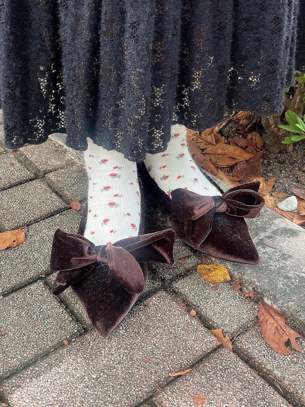 ブラック系のスカート、ブラウン系のパンプス、パープル系のニット/セーターを着用したレディースの秋コーディネートの3枚目の写真