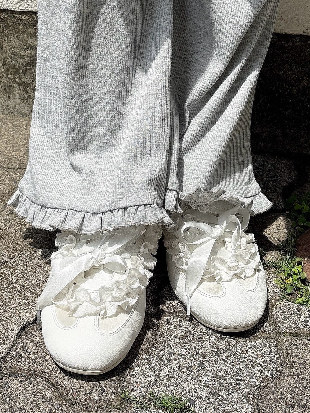 ブルー系のワンピース、グレー系のスウェットパンツ、ホワイト系のスニーカーを着用したレディースの春コーディネートの7枚目の写真