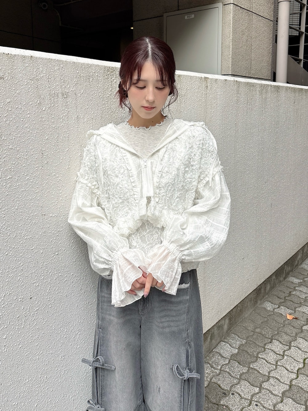 ホワイト系のブルゾン、グレー系のTシャツ/カットソー、グレー系のデニムパンツを着用したレディースの秋コーディネートの3枚目の写真