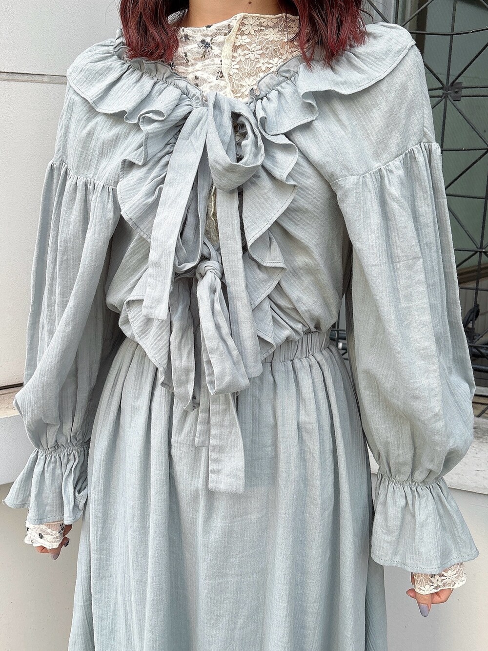 グリーン系のワンピース、ホワイト系のTシャツ/カットソー、ブラック系のパンプスを着用したレディースの冬コーディネートの3枚目の写真