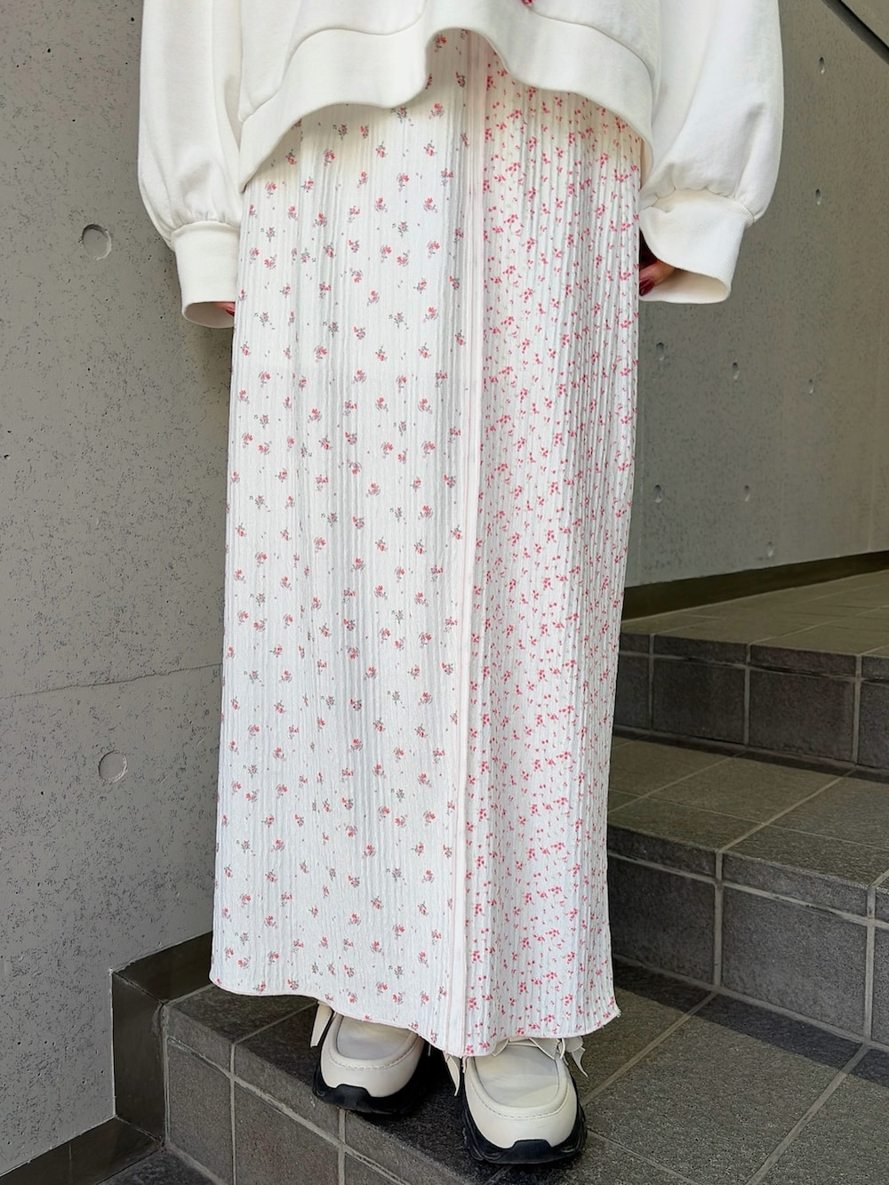 ホワイト系のスウェット、ホワイト系のショルダーバッグ、ピンク系のスカートを着用したレディースの冬コーディネートの7枚目の写真