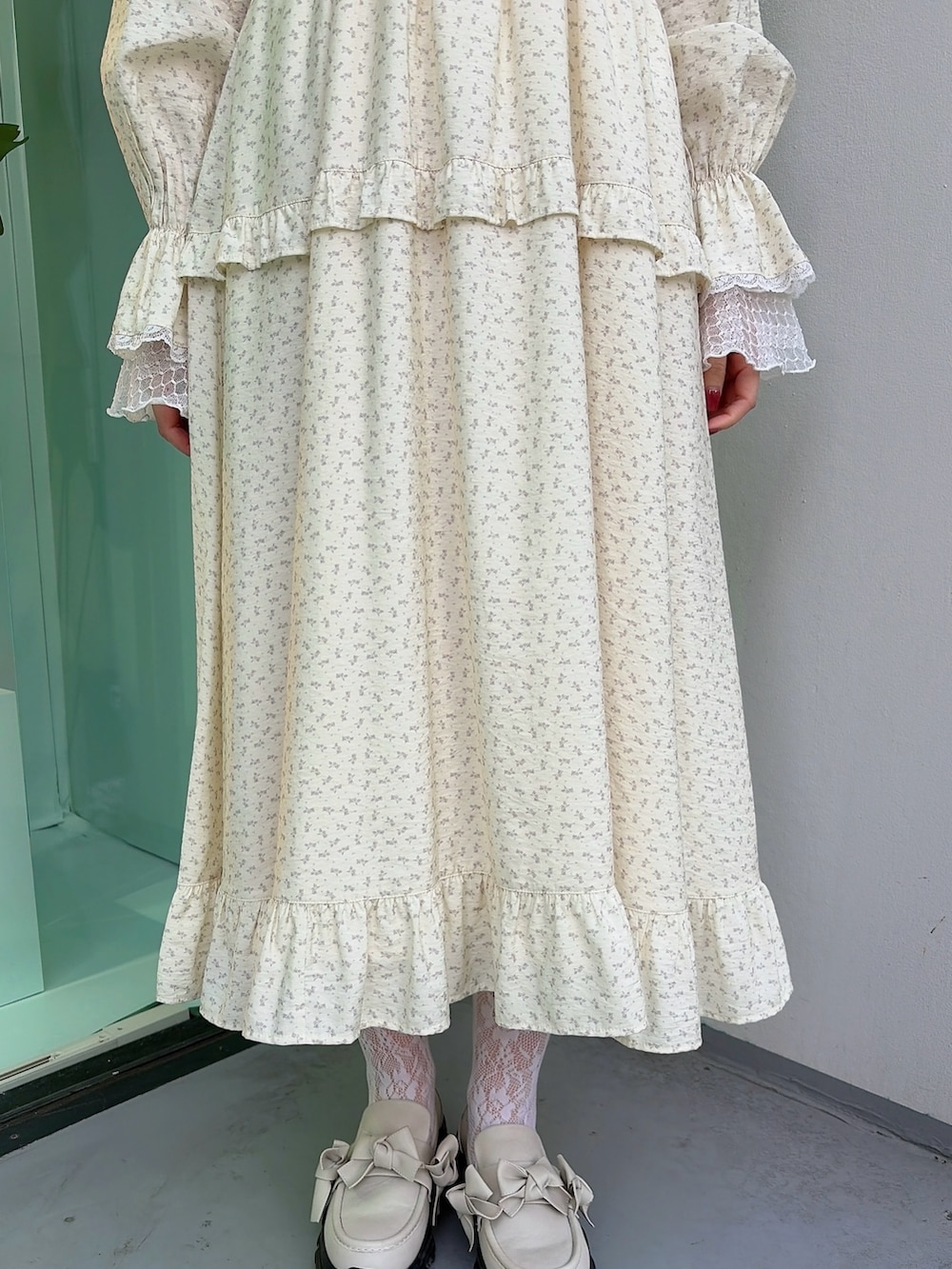 ホワイト系のTシャツ/カットソー、ベージュ系のワンピース、ホワイト系のスニーカーを着用したレディースの冬コーディネートの6枚目の写真