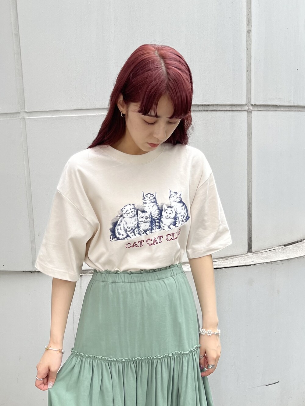 ホワイト系のトートバッグ、レッド系のサンダル、グリーン系のスカートを着用したレディースの春コーディネートの4枚目の写真