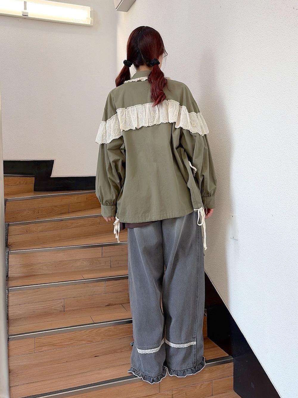 グリーン系のミリタリージャケット、ブラウン系のTシャツ/カットソー、グレー系のデニムパンツを着用したレディースの秋コーディネートの3枚目の写真