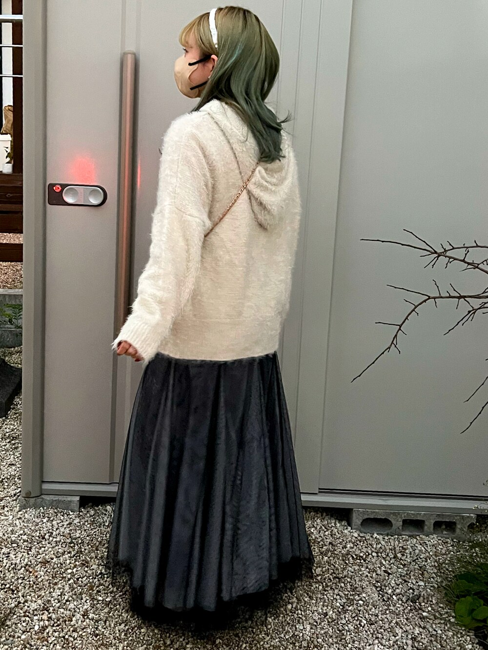 ブルー系のデニムパンツ、ブラック系のスカートを着用したレディースの冬コーディネートの2枚目の写真