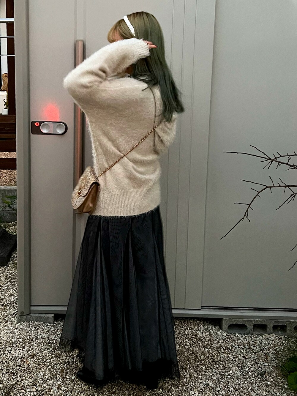 ブルー系のデニムパンツ、ブラック系のスカートを着用したレディースの冬コーディネートの3枚目の写真