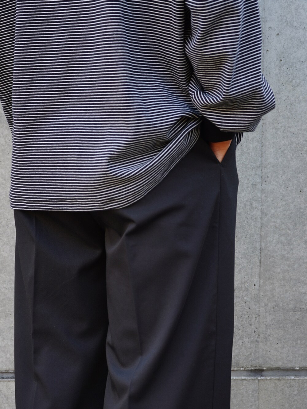 ブラック系のTシャツ/カットソー、ブラック系のスラックス、ブラック系のローファーを着用したメンズの秋コーディネートの4枚目の写真