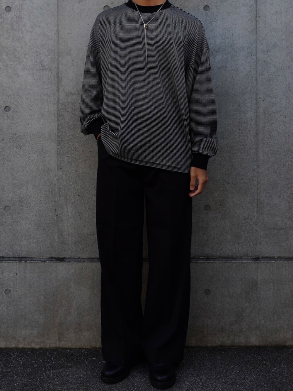 ブラック系のTシャツ/カットソー、ブラック系のスラックス、ブラック系のローファーを着用したメンズの秋コーディネートの2枚目の写真